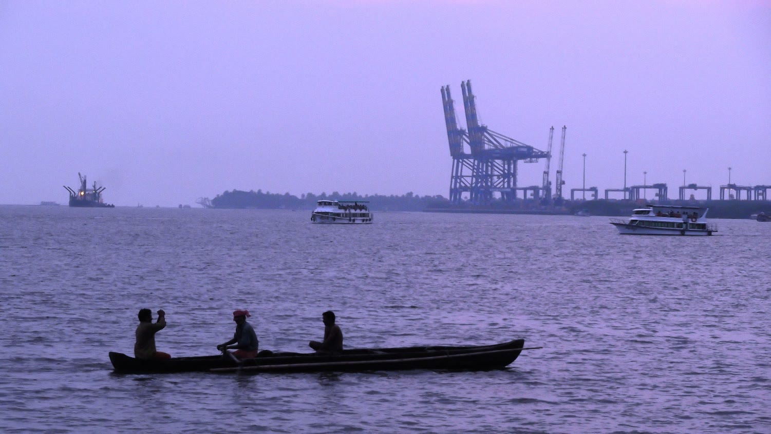 The lights of Marine Drive in Kochi reflected on the water at night.